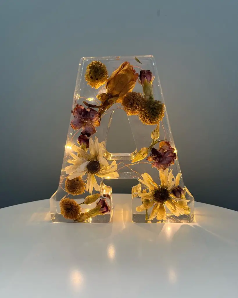 Image of a resin letter filled with lights and flowers.